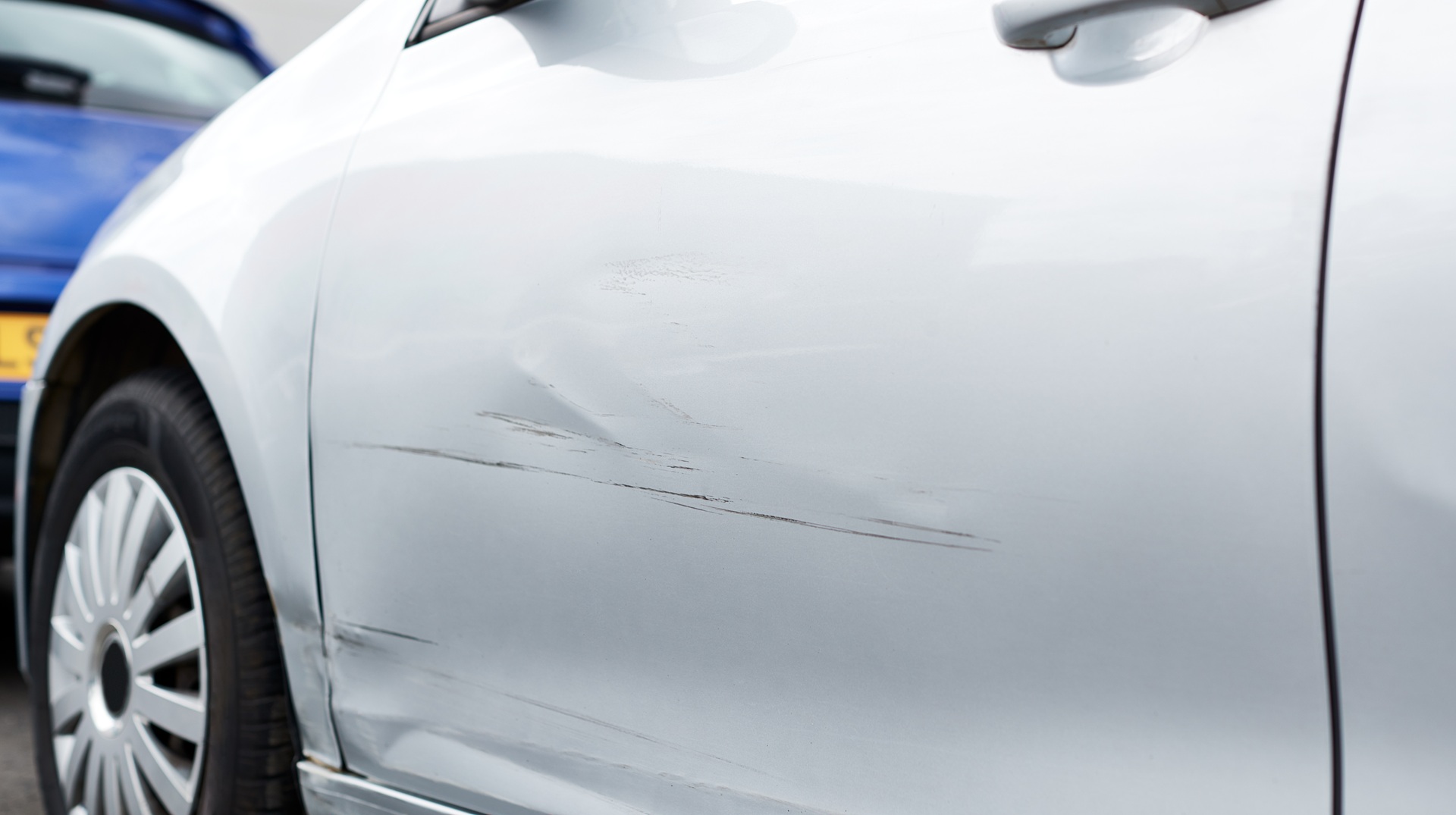 Detail Of Damage To Door Of Vehicle In Car Park With Scratched Panel Detail Of Damage To Door Of Vehicle In Car Park With Scratched Panel