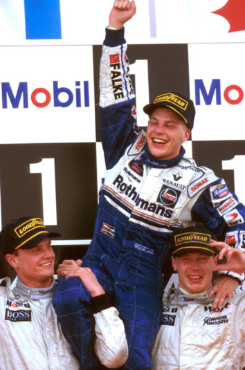 F1 - Jerez 1997. Mika Hakkinen and David Coulthard (McLaren Mercedes) hold Jacques Villeneuve, the new World Champion aloft on the podium