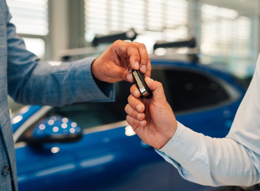 envato man hands over car keys to another in dealership 2026 03 09 01 54 43 utc