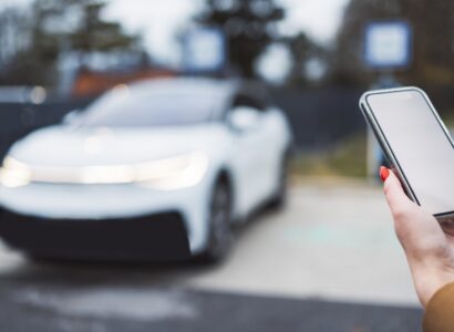 woman using mobile phone near electric car 2026 03 18 04 34 35 utc