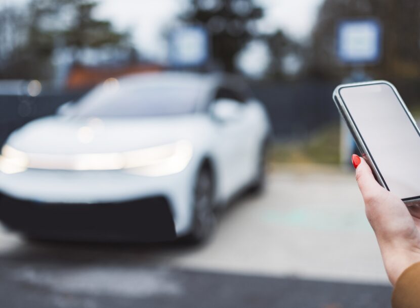 woman using mobile phone near electric car 2026 03 18 04 34 35 utc